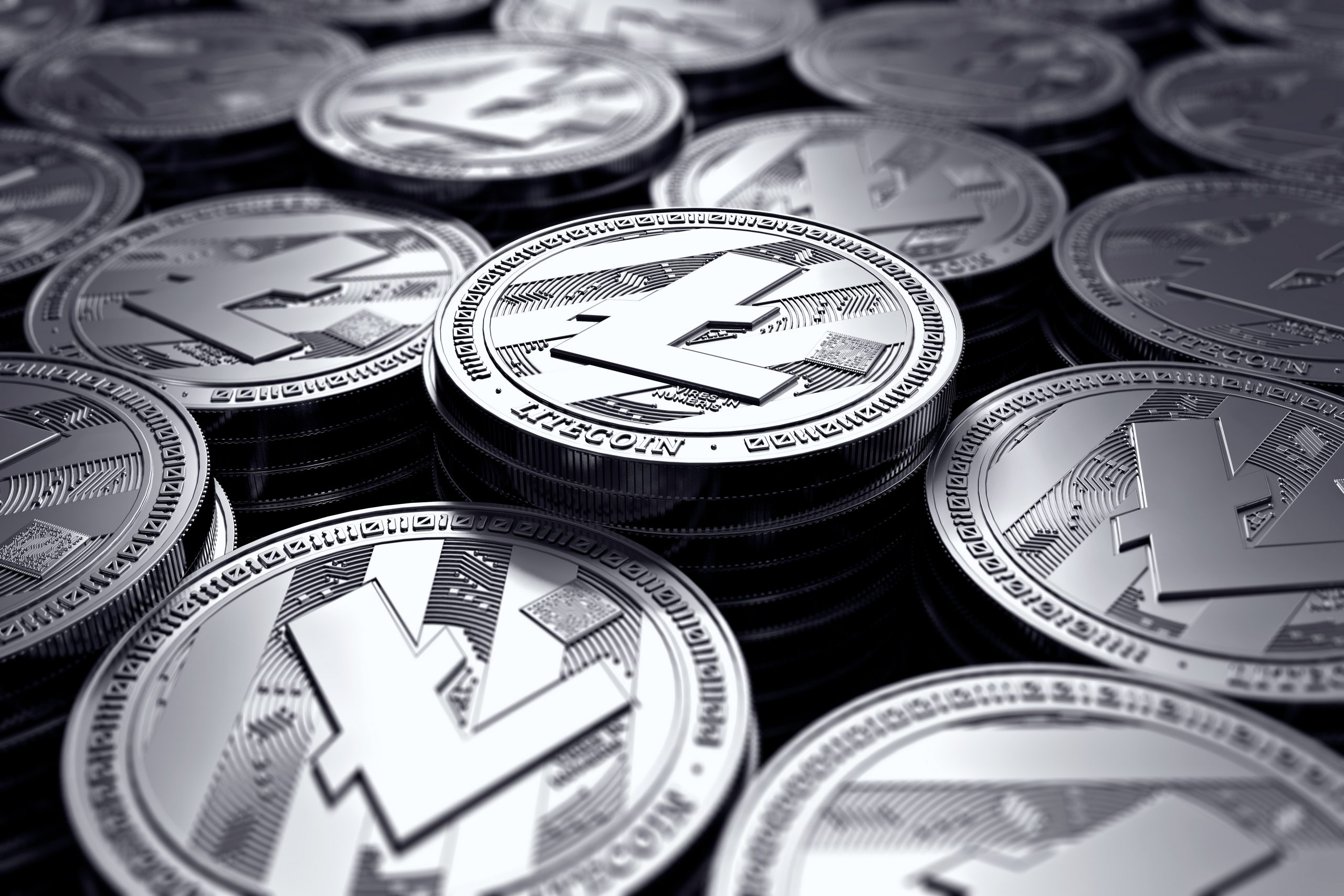 A large pile of silver litecoin sits on a dark background